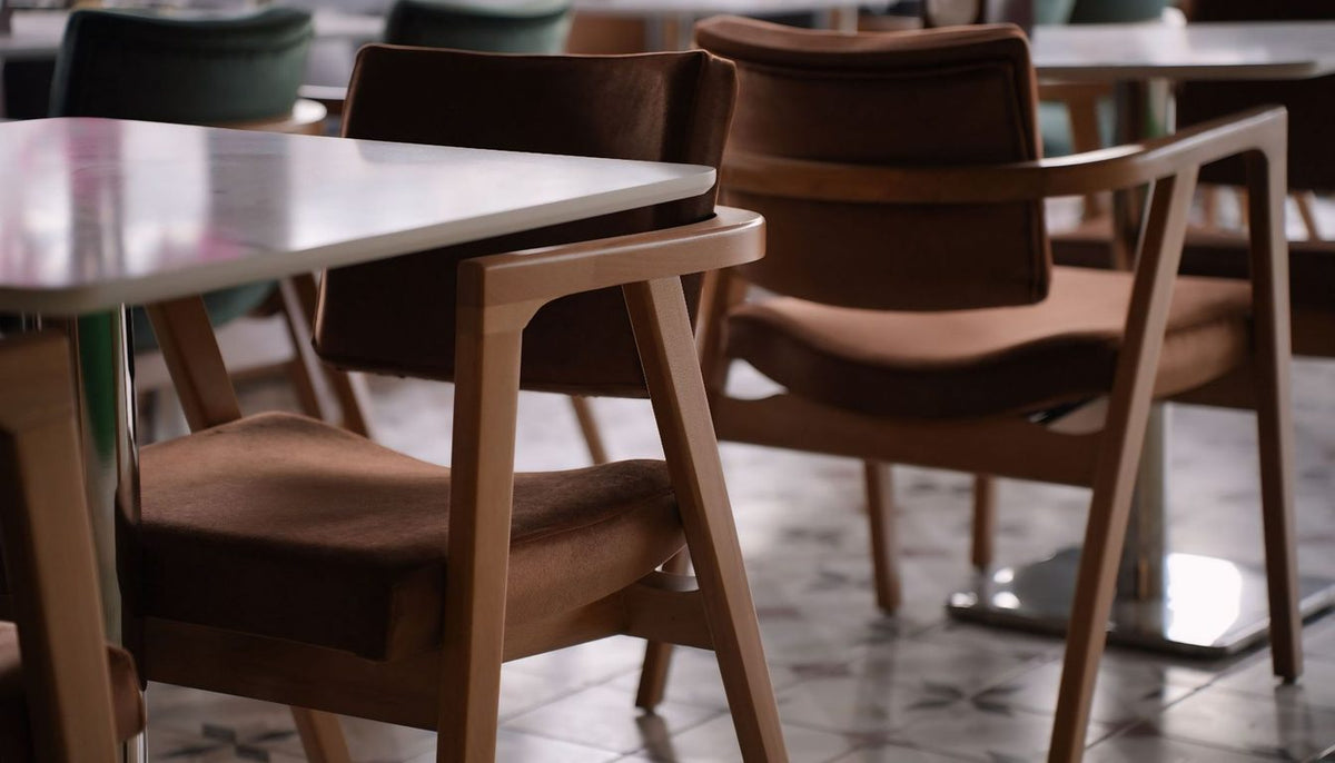 Chaises de salle à manger en bois et assise tissu, disposées autour d'une table claire Image