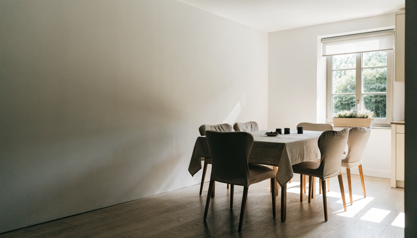 Salle à manger claire, chaises habillées de housses beiges autour d'une table