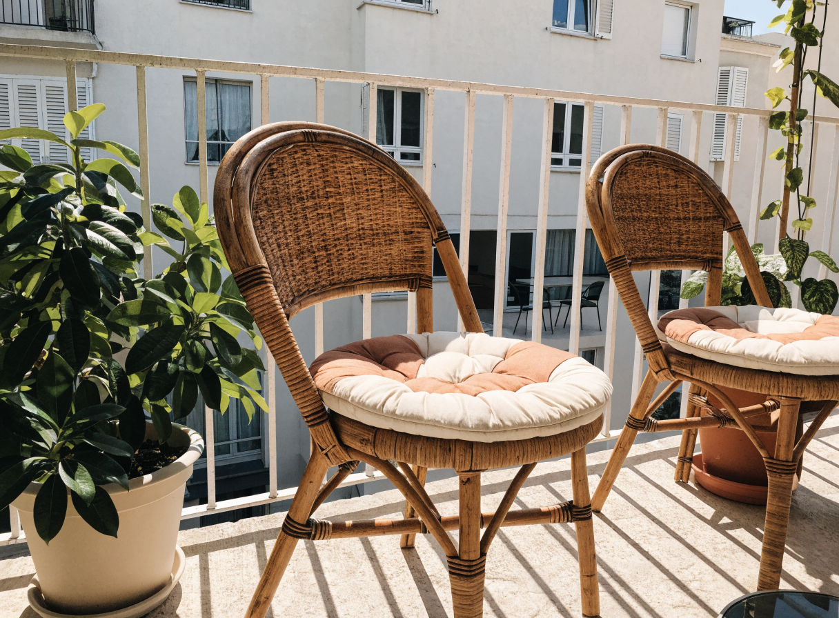 Galettes rondes matelassées sur des chaises bistrot en rotin, sur un balcon Image